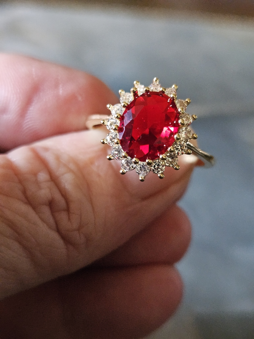 Gold Tone Ring with Oval Red Center Gem and Halo Accents